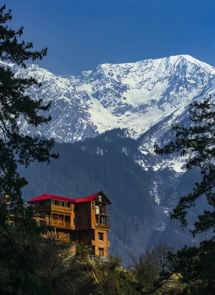 A image of a house in hill station with snow mountains view