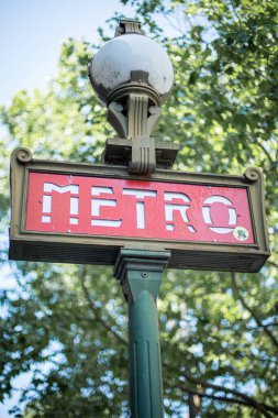 Açık havada Paris 'te metro tabelasını imzalayın. Arkasında ağaçlar var. Kaliteli bir fotoğraf.