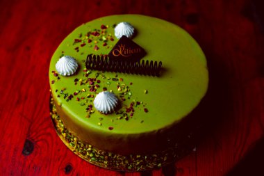 Tahta arka planda kremalı ve çikolata kaplı çikolatalı pasta.