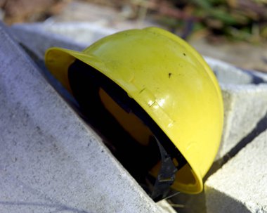A yellow construction workers helmet on cinder blocks