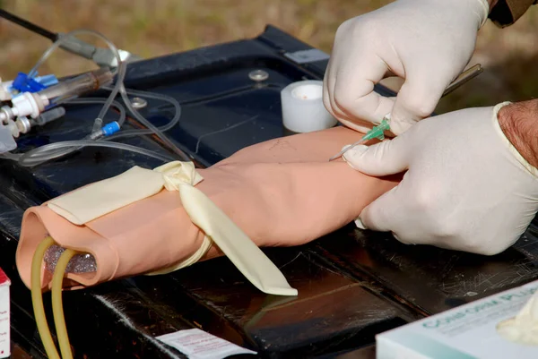 A medical provider practicing inserting an IV catheter