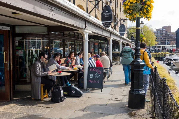 Londra 'daki St. Katharine rıhtımındaki kafe ve restoranlarda oturan insanlar
