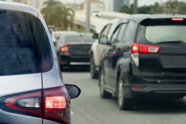Asfalt yoldaki gümüş arabanın arka tarafı fren lambasını aç ve yolculuğun amacına doğru git. Yoğun saatlerde iş seyahati. Gün boyunca diğer arabaların çevresi bulanıklaştı.