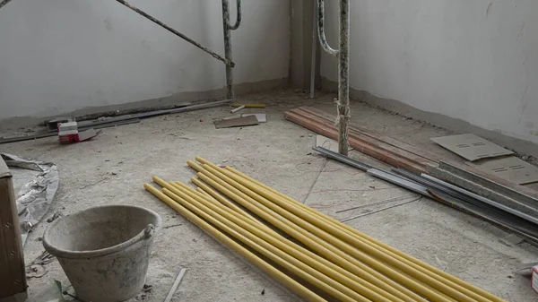 Yellow PVC pipe piled up in a construction building. along with other construction equipment placed inside the building.