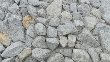 Çakıl taşı dokusunun üstünde. Çakıl taşı arka planı. Açık gri yakın plan büyük kayalar. Yol arkaplanının yanındaki duvara git.