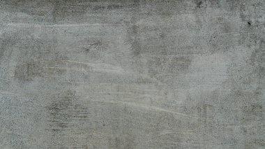 Arka plan ve beton duvarın üstü açık gri renkte. Çimento yüzeyinde eski sıva parçaları var. Gruplar halinde yüzen güzel hava kabarcıkları var. Eski kattaki siyah küfler düzensiz..