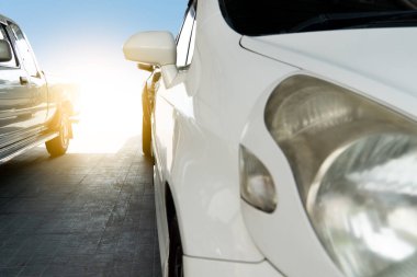 Gri fayansların üzerine park edilmiş arabaların önü. Garajda parlak ışık arkaplanı.