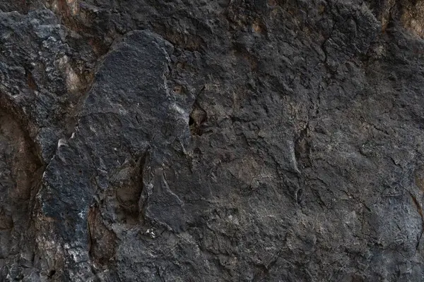 Taş zemin eşsiz pürüzlü bir yüzeye ve koyu renge sahiptir. Arkaplan ve doku için.