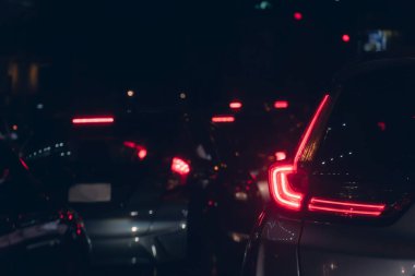 Geceleri şehirdeki trafik sıkışıklığı soyut ve bulanık. Fren arabasının stop lambasını kapat. Bulanık arkaplan.