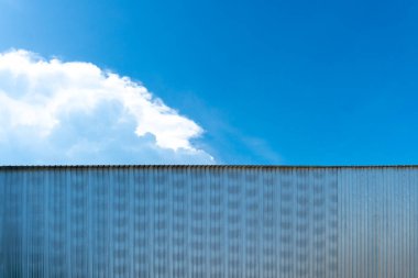 Çatısı olan bir bina için metal levha. Gökyüzünün altında. Mavi gökyüzü ve beyaz bulutların arkaplanı.