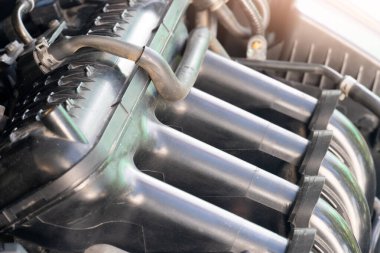 Modern bir arabanın motorunu kapatın. Arkaplanı bulanık dört silindirli. Ön motorun korumasını açın. Eğimli piston çubuğunu ortaya çıkarmak için ön kapağı açın.