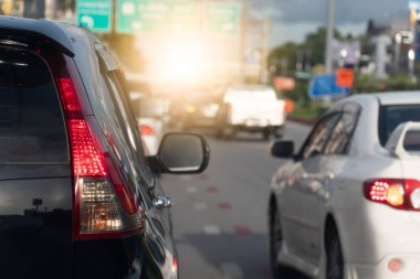 Aspahlt yolunda siyah arabanın arka tarafında. Sabah saatlerinde iş ortamında araba taşımacılığı fren lambasını yakar. Trafik sıkışıklığı ve araba kuyrukları.
