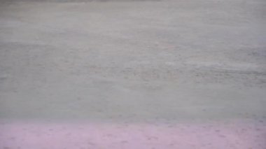 Bölge beton zemindeki dalgalarla dolu. Su yüzeyine düşen yağmur damlaları.