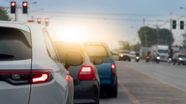 Gün ışığında trafik ışıklarında bir sürü araba durdu. Daha fazla araç ve trafik ışıklarının bulanık arkaplanıyla odaklanan arabalar yoğun bir kavşağı işaret ediyor.