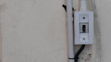 Beton duvarlara elektrik şalterleri yerleştirilmiş. PVC elektrik bağlantıları yakınında kurulum.