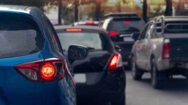 Yoldaki mavi arabaların ulaşım lüksü. Kavşakta trafik işaretlerini yaymak için açık ışık freni bekliyor. Yoğun trafik. Birçok araba kuyrukta ve trafik sıkışıklığında.