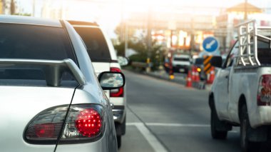 Sedan arabanın gümüş renginin arka tarafında. Fren lambasını yak. Arabalar kavşaklarda trafik ışıklarında durur. Şehirdeki trafiğin arka planı.