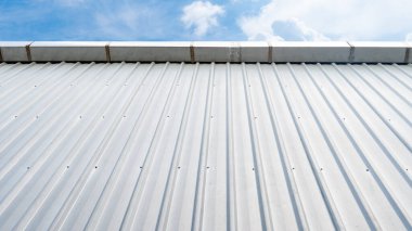 Bronz metal tavan duvarı. Matematik kağıdının temel rengi. Drenaj kanalı üste sabitlendi. Arka plan için mavi gökyüzü ve beyaz bulutlar.