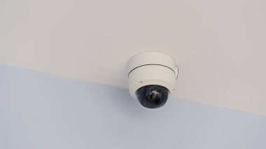Kapalı alan güvenlik kamerası. Evin önündeki hareketlilikten dolayı bulanık bir iç cam. Beyaz tavan panellerinin altına kurulmuş.