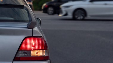 Sabahları arabanın arka tarafında araba sürüyorum. Sağ tarafta trun sinyaliyle yolda dur. Ana yoldaki hareket hızı arabalarının arka planı bulanık..