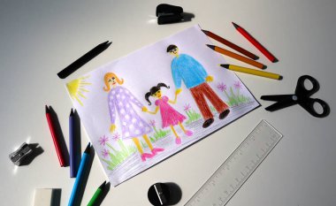 Renkli kalemlerle çocuk çizimlerinin olduğu bir açıdan çek. Resim aileyi gösteriyor. Anne, baba ve kız doğada yürüyor. Ofis ekipmanları, kalemler, kesiciler, silgi her yerde. Beyaz arkaplan.