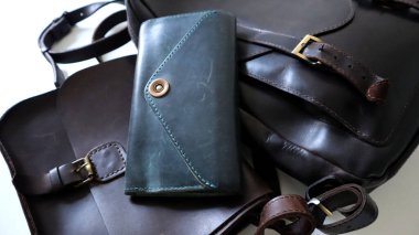 Çılgın at derisi eşyalar. Kadın omuz çantası, cüzdan, çanta, sırt çantası. Siyah, kahverengi, turkuaz renkler. Çeşitli altın renkli aksesuarlar, eskimiş eski dokular. Beyaz arka plan. Makro fotoğraf