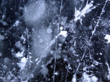 Donmuş bir nehrin Macro fotoğrafı. Soyut doku arkaplanı. Beyaz, gri, koyu mavi, siyah renkler. Kaotik noktalar ve çizgiler. Çatlaklar. Ve donmuş yuvarlak su kabarcıkları.