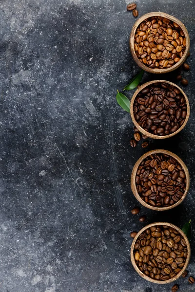 Płaskie Układanie Czterech Różnych Odmian Ziaren Kawy Ciemnym Marmurowym Tle — Zdjęcie stockowe