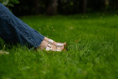 Çimlerin üzerinde yeşil kotlu kadın bacakları