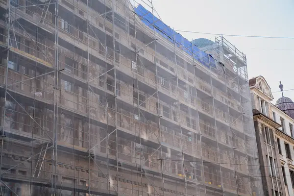 stock image new construction of the old town in the center with scaffolding systems and protective scaffolding net for construction work