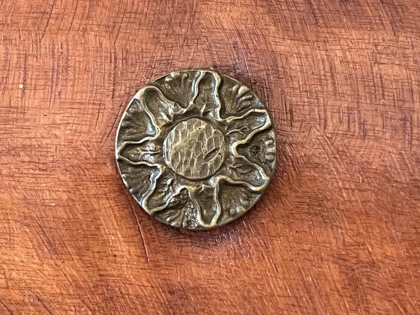 old rusty metal coin on a wooden background