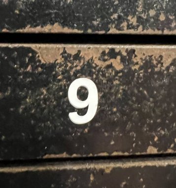 number nine written on a brick wall