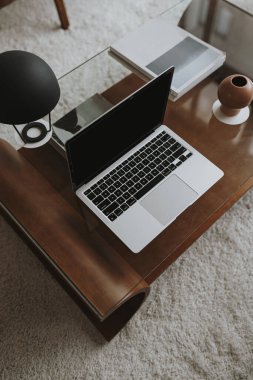 Estetik ofis çalışma masası. Laptop bilgisayar, lamba, koyu kahverengi kahve masasında çay mumu. İş, iş kavramı