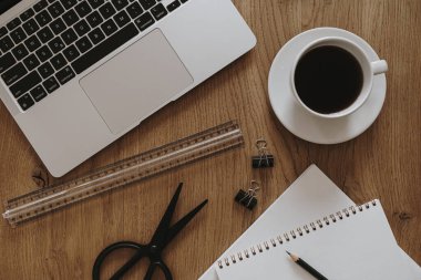 Estetik ofis masası çalışma alanı. Dizüstü bilgisayar, defter, sehpadaki kahve fincanı. Etkileyici yaşam tarzı blog arka planı