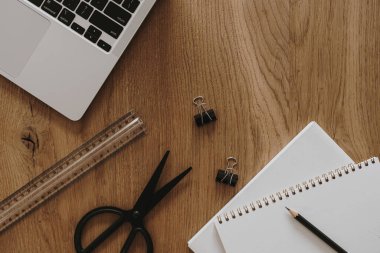 Laptop, defter kahverengi tahta masa arkasında. Düzlük, üst görünüm estetik minimal serbest yazar, blog yazarı ofis çalışma alanı