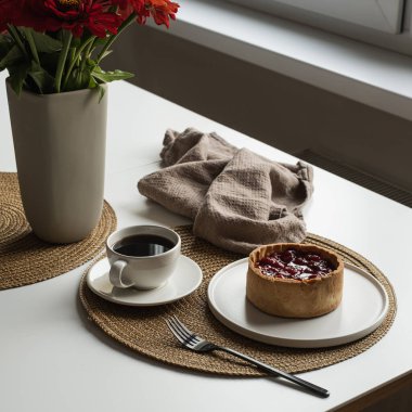 Sabah kahvaltısı, kahve ve çilekli turta. Tatlı, kahve, çiçek buketi, keten battaniye, çatal beyaz masa.