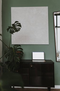 Klasik ahşap konsol masasında dizüstü bilgisayar, tropikal bitki canavarı. Estetik zarif blog, çevrimiçi dükkan, mağaza, sosyal medya şablonu