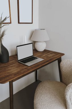 Masada boş ekran, lamba ve çiçek buketi olan dizüstü bilgisayar. Estetik etkileyicisi Boho ev yapımı iç mekan tasarım şablonu ve kopya alanı. Çevrimiçi mağaza, blog markalaşması