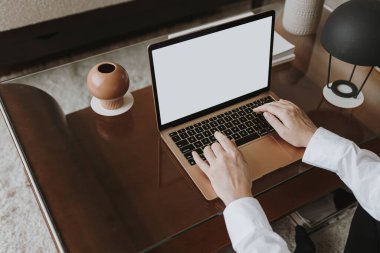 Estetik minimalist ofis çalışma masası. Dizüstü bilgisayarla çalışan biri. Boş model ekran şablonu. İş, iş kavramı