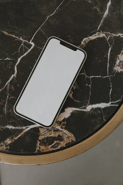 Flatlay mobile phone on black marble side table. Aesthetic elegant blog, online shopping, online store, social media branding template with blank copy space