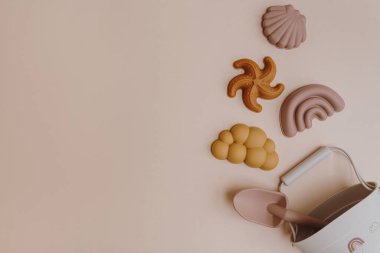 İskandinav tarzı plaj oyuncakları su ve kumla oynamaya ayarlı. Tarafsız pastel renklerde estetik bebek aletleri. Boşluğu kopyala, düz yat, üst görünüm