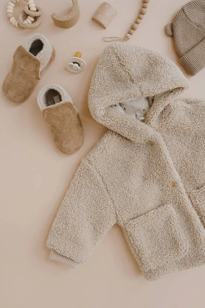 暖かい冬の子供のジャケット スエードブーティー ペースメーカー おもちゃ 中性ベージュを基調としたベビー服やアクセサリー ファッション北欧の子供服 フラットレイアウト トップビュー — ストック写真