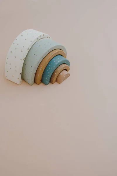 Colourful wooden rainbow stacking toy on neutral beige background. Aesthetic Scandinavian nordic eco stylish baby, children\'s toy. Creativity concept