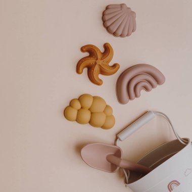 İskandinav tarzı plaj oyuncakları su ve kumla oynamaya ayarlı. Tarafsız pastel renklerde estetik bebek aletleri. Boşluğu kopyala, düz yat, üst görünüm