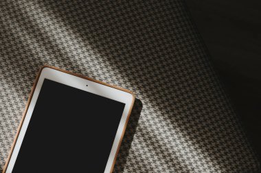 Aesthetic chic online store, online shopping, blog, social media branding composition. Tablet with blank copy space screen on seamless classic fabric pattern background with sunlight shadow