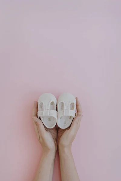 White Cotton Cute Baby Shoes Women Hands Pastel Pink Background — Stock Photo, Image