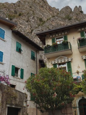 Kırsal İtalyan mimarisi. Geleneksel tarihi Avrupa kır binaları. Ahşap pencereleri, çiçekleri ve çiçek açan ağaçları var. Estetik yaz tatili seyahat kavramı