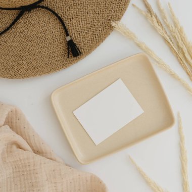 Kağıt kağıtlar, boş kopya alanı, hasır şapka ve beyaz arka planda kurutulmuş otlar.