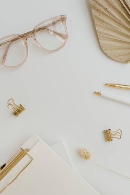 Flatlay boş kopya alanı. Pano, bronz yelpaze yaprağı, gözlük, beyaz arka plan klipsleri. Ofis masası çalışma alanı. Estetik iş, iş şablonu. Düz yatış, üst görünüm