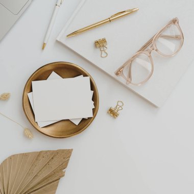 Kağıt kağıtta boş kopya alanı, beyaz arka planda altın rengi şeyler var. Estetik zarif davet veya kartvizit şablonu